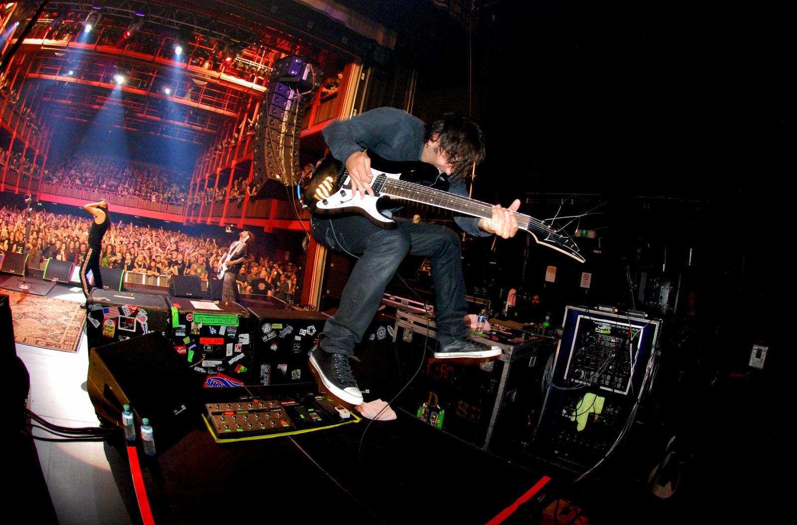 Wes Geer performing live with his guitar under stage lights