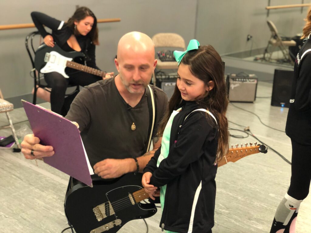 A Rock to Recovery facilitator working one-on-one with a participant on guitar